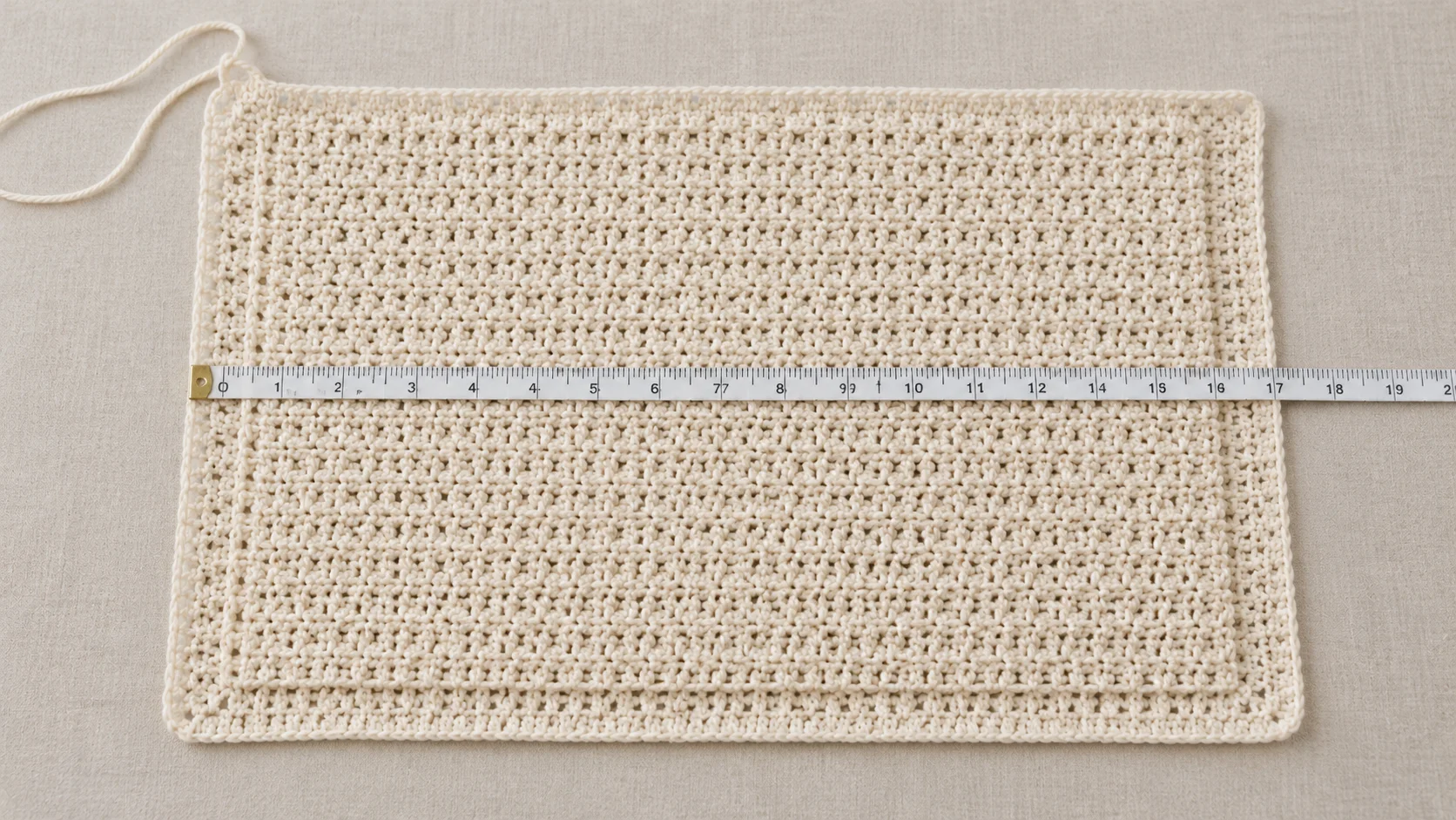 Crochet baby blanket body measured before the border is added, with room visible around the edges.